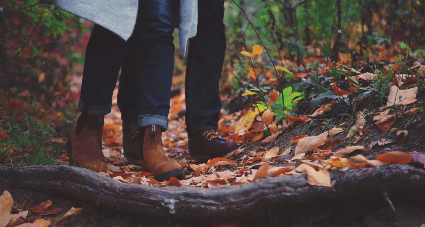 Two people walking in the woods in autumn