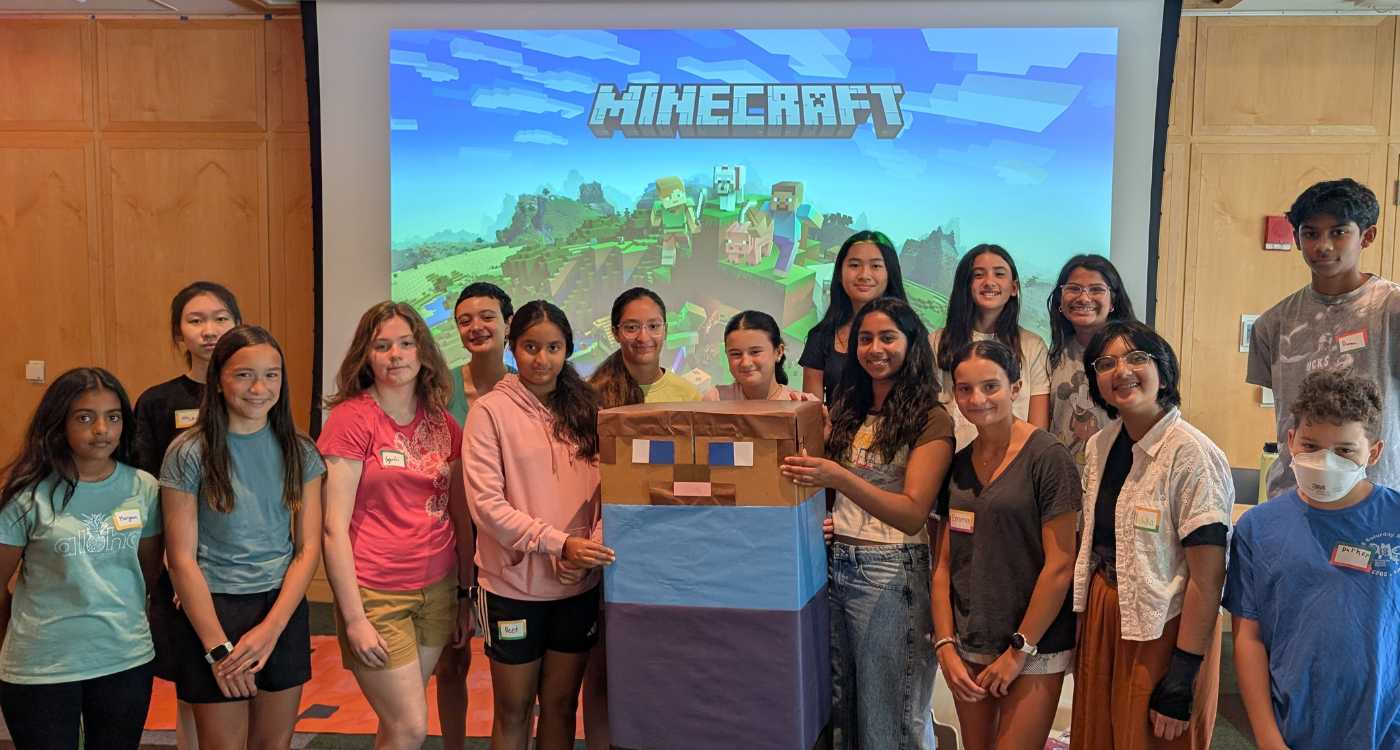 A group of teen summer volunteers pose with decorations for the 2025 TSV Minecraft Mania event.