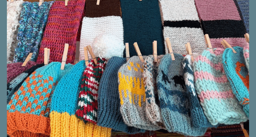 Image of hats and scarves hanging on a clothes line.