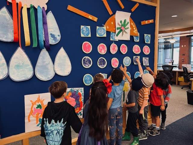 Kids pointing at a display of art on a bulletin board at the Princeton Public Library